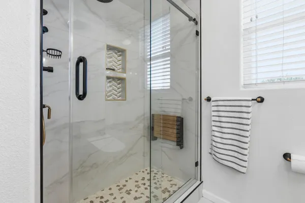 a bathroom with a shower a mirror and a sink
