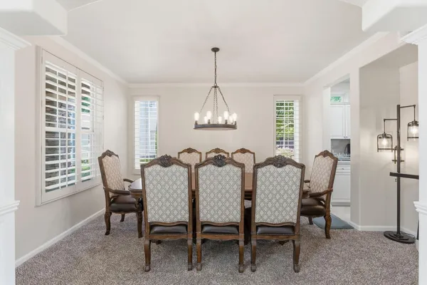 a view of a dining room with furniture a chandelier and wooden floor
