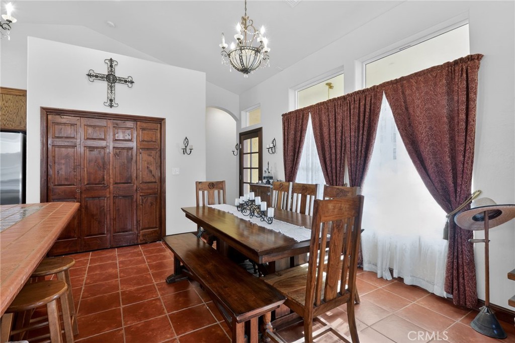 11701 Back Canyon Road Caliente, CA 93518 - Photo 12 of 26 a dining room with wooden floor a chandelier a wooden table and chairs