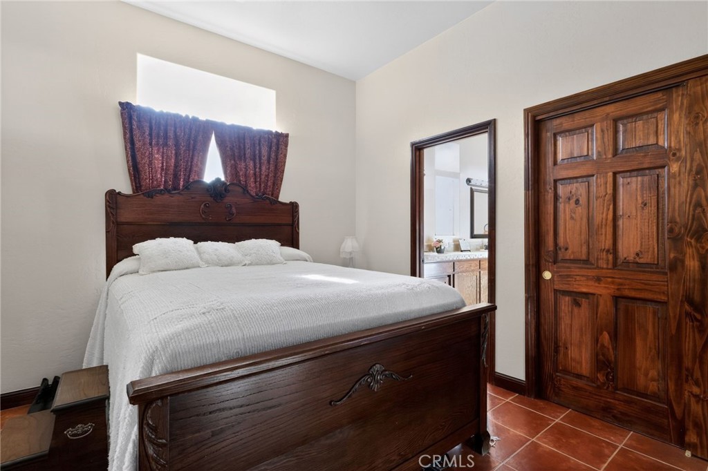 11701 Back Canyon Road Caliente, CA 93518 - Photo 14 of 26 a bedroom with a large bed and wooden floor