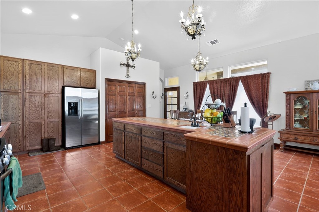 11701 Back Canyon Road Caliente, CA 93518 - Photo 10 of 26 a kitchen with stainless steel appliances granite countertop a refrigerator a sink dishwasher a oven and a dining table with wooden floor