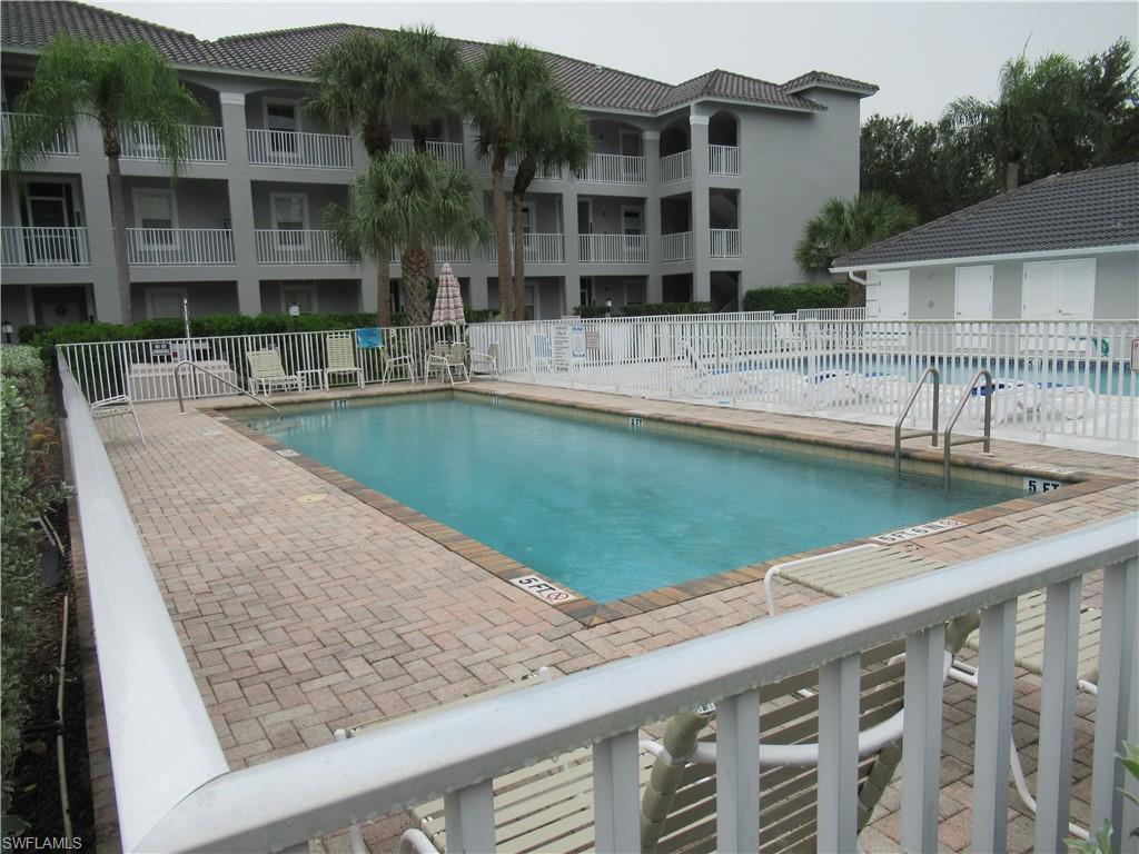 519 Roma Court, Unit 2103 Naples, FL 34110 - Photo 24 of 27 a view of swimming pool with outdoor seating and house in the background