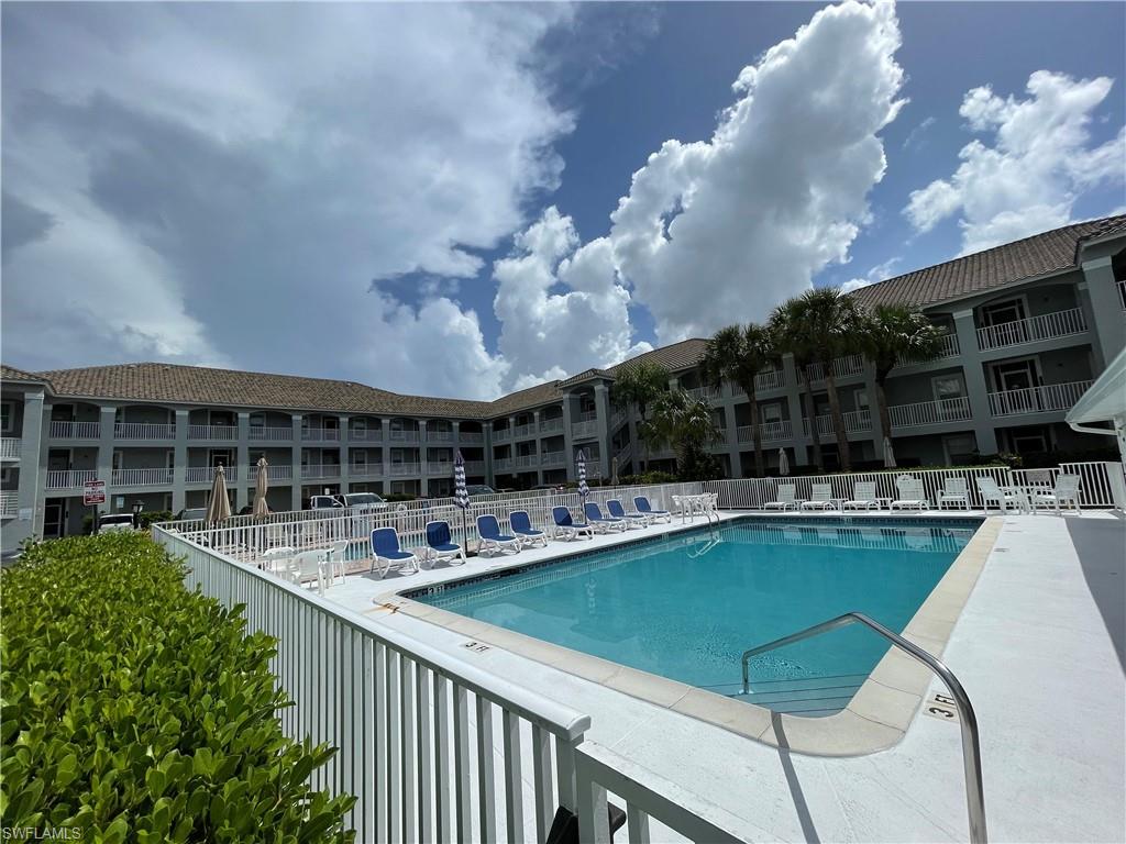 519 Roma Court, Unit 2103 Naples, FL 34110 - Photo 25 of 27 a view of a house with pool and chairs