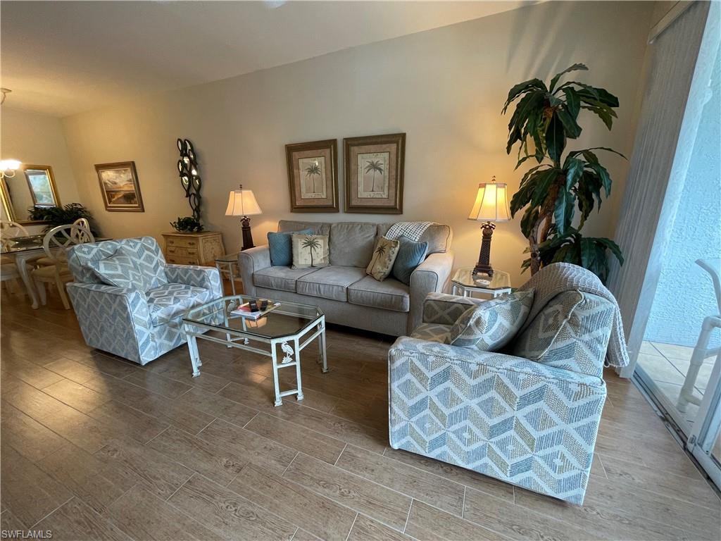 519 Roma Court, Unit 2103 Naples, FL 34110 - Photo 3 of 27 a living room with furniture and a lamp