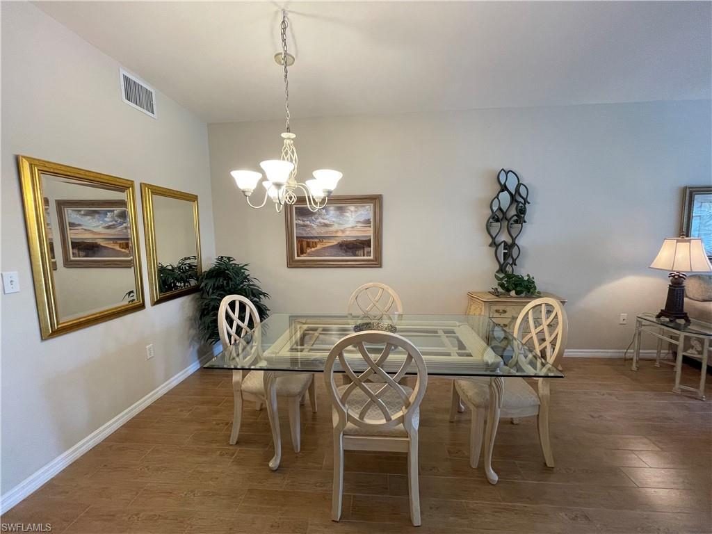 519 Roma Court, Unit 2103 Naples, FL 34110 - Photo 5 of 27 a view of a dining room with furniture and wooden floor