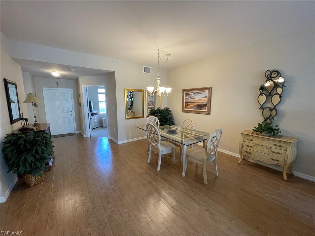 519 Roma Court, Unit 2103 Naples, FL 34110 - Photo 6 of 27 a view of a dining room with furniture and wooden floor