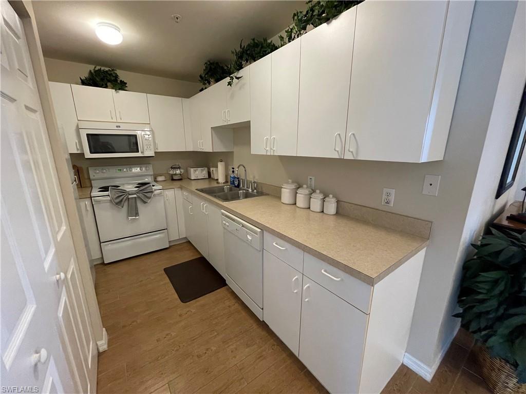 519 Roma Court, Unit 2103 Naples, FL 34110 - Photo 9 of 27 a kitchen with stainless steel appliances a sink a stove a microwave a refrigerator a sink and cabinets