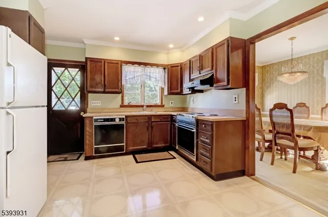 a kitchen with stainless steel appliances granite countertop a stove top oven a sink refrigerator and cabinets