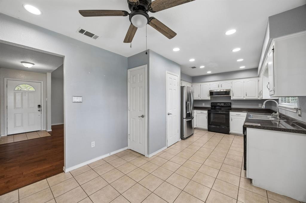 709 Bowie Street Forney, TX 75126 - Photo 11 of 27 a kitchen with stainless steel appliances kitchen island granite countertop a refrigerator and a sink