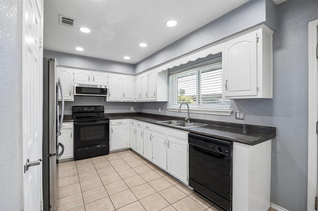 709 Bowie Street Forney, TX 75126 - Photo 12 of 27 a kitchen with kitchen island granite countertop a stove sink and cabinets