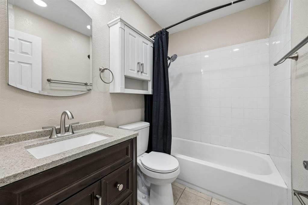 709 Bowie Street Forney, TX 75126 - Photo 21 of 27 a bathroom with a granite countertop sink toilet and shower