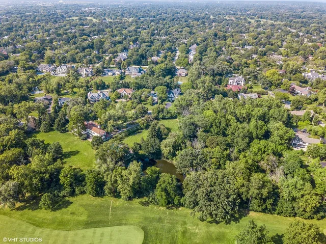 an aerial view of residential houses with outdoor space and trees