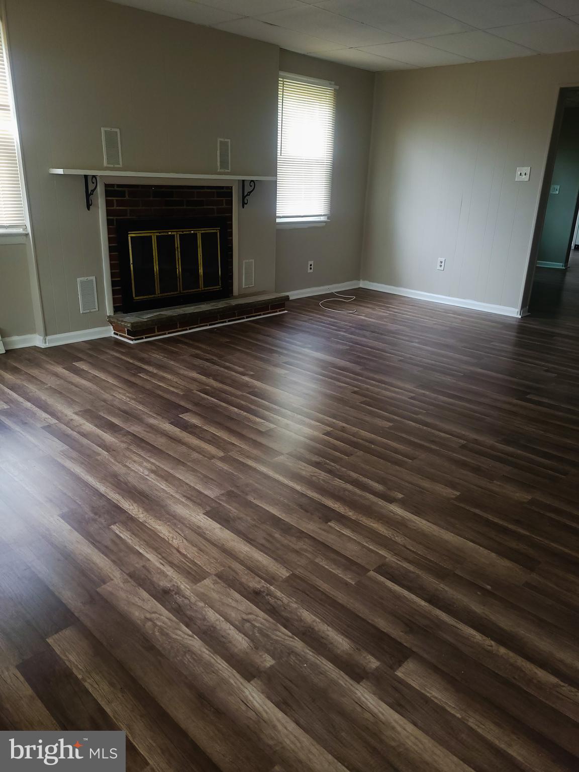 601 Division Street Gloucester City, NJ 08030 - Photo 2 of 4 an empty room with wooden floor fire place and windows