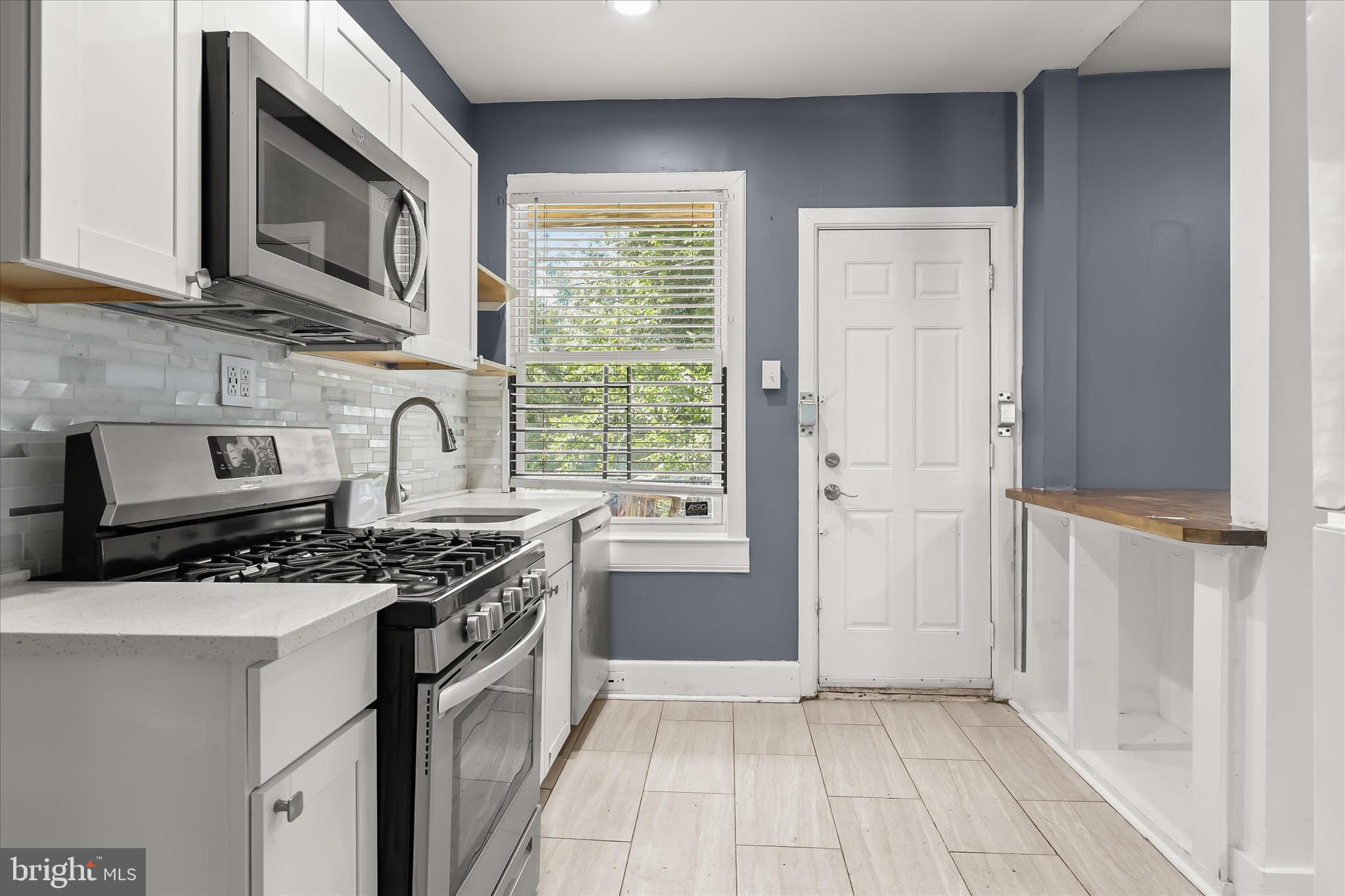 3534 Overview Road Baltimore, MD 21215 - Photo 12 of 28 a kitchen with stainless steel appliances granite countertop a stove a sink and a microwave