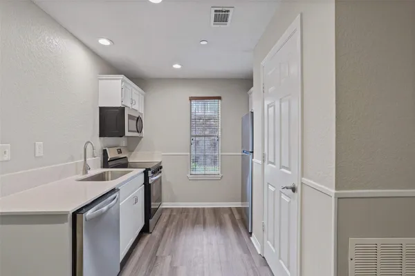 a kitchen with a sink appliances and cabinets