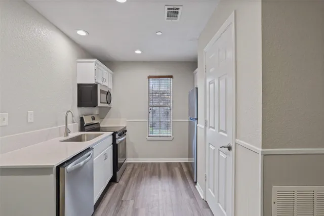 a kitchen with a sink appliances and cabinets