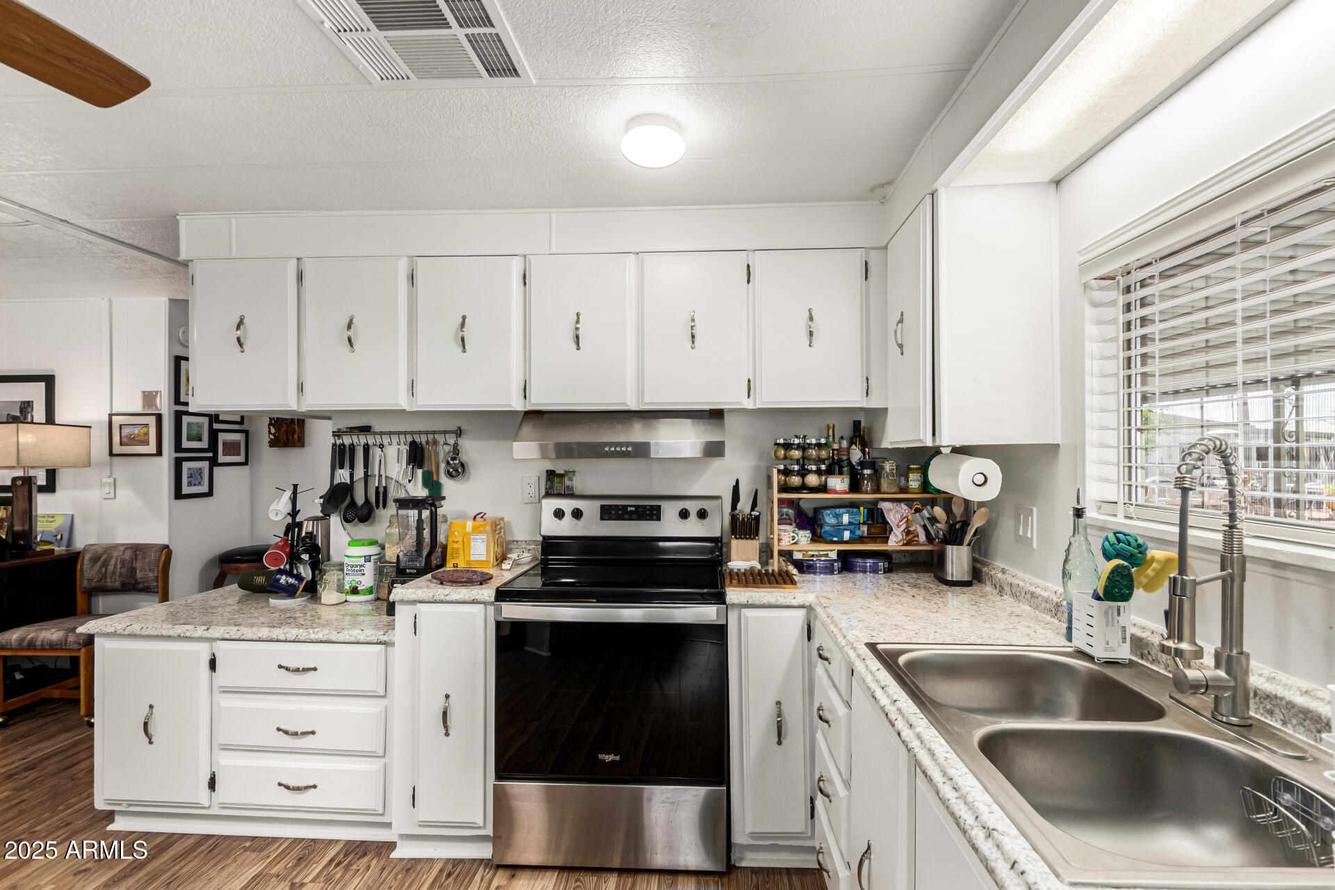 661 South Hawes Road, Unit 52 Mesa, AZ 85208 - Photo 7 of 36 a kitchen with granite countertop a sink stainless steel appliances and cabinets