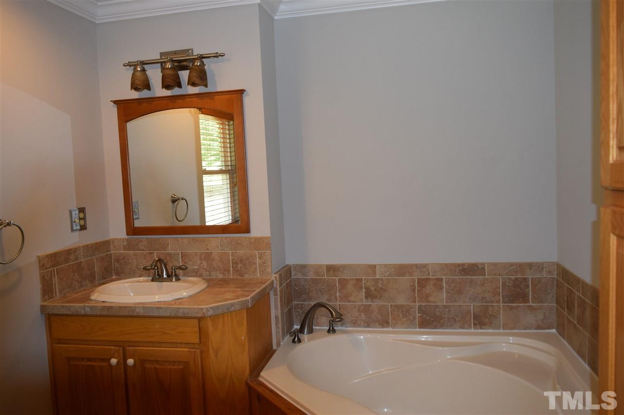 89 Mountain Ridge Road Rougemont, NC 27572 - Photo 14 of 16 a bathroom with a granite countertop sink and a bathtub