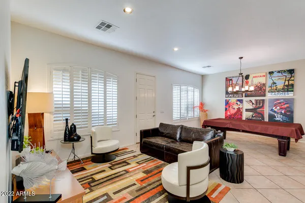 a living room with furniture a flat screen tv and a window