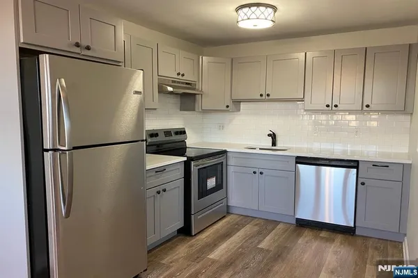 a kitchen with stainless steel appliances a refrigerator sink and cabinets