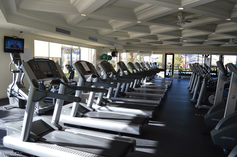 87 Tall Ruff Drive Las Vegas, NV 89148 - Photo 18 of 71 A well-equipped fitness center awaits, featuring a coffered ceiling and numerous cardio machines.