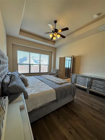 a bedroom with a bed chandelier and a window