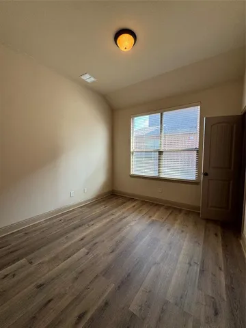a view of a room with wooden floor and window