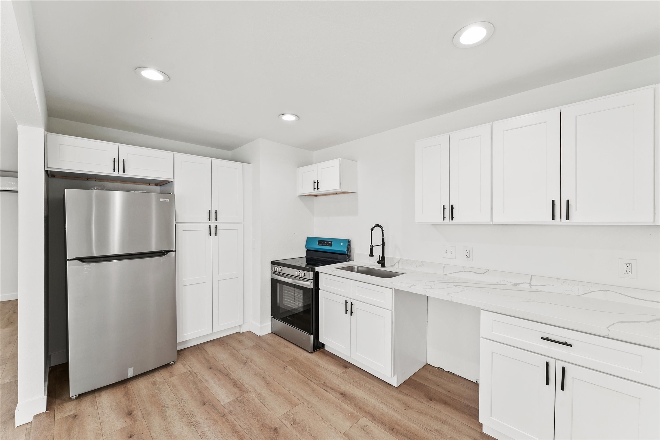 5406 Firefly Street Houston, TX 77017 - Photo 5 of 29 a kitchen with a sink a refrigerator and white cabinets