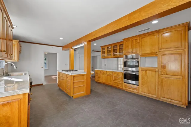 a kitchen with stainless steel appliances granite countertop a stove a sink and a refrigerator