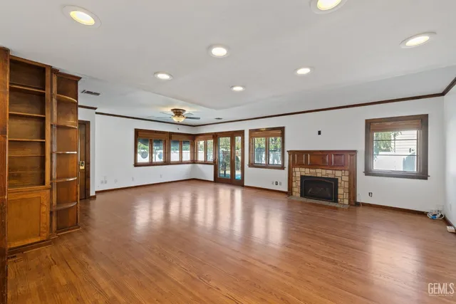 a view of an empty room with window and fire place