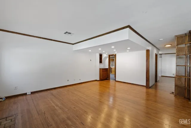 a view of an empty room with wooden floor