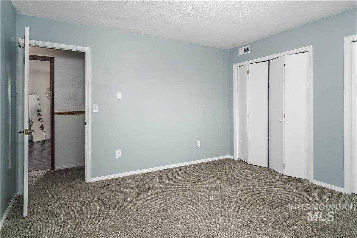 1401 Chokecherry Drive Pocatello, ID 83204 - Photo 34 of 46 Carpeted room with light blue walls, white trim, and white bi-fold closet doors