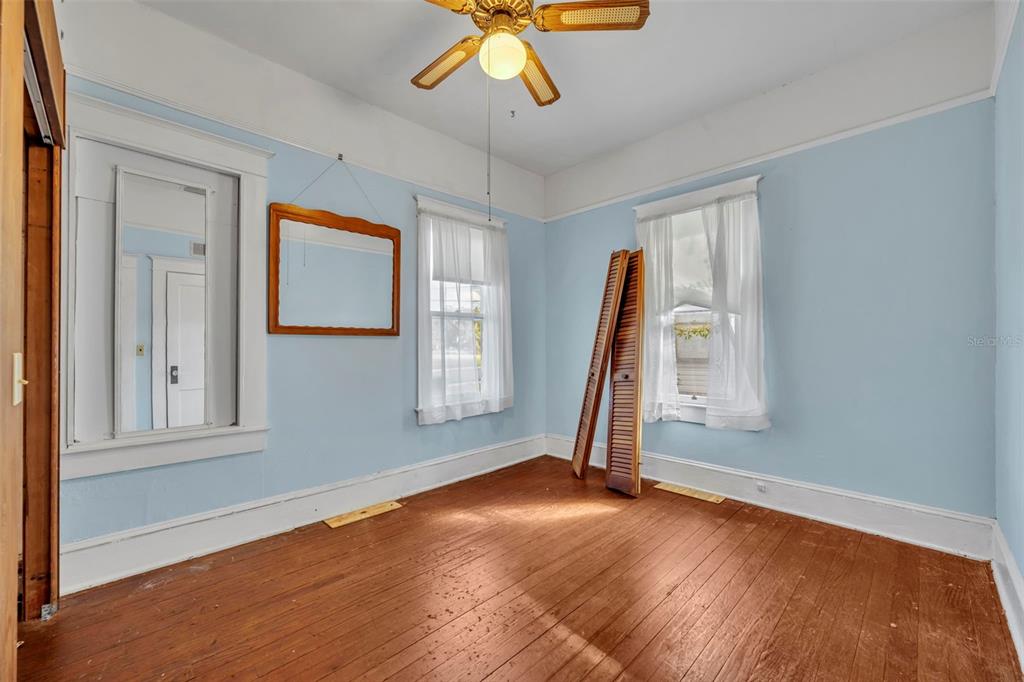 207 Perkins Street Leesburg, FL 34748 - Photo 11 of 31 a view of empty room with wooden floor and fan