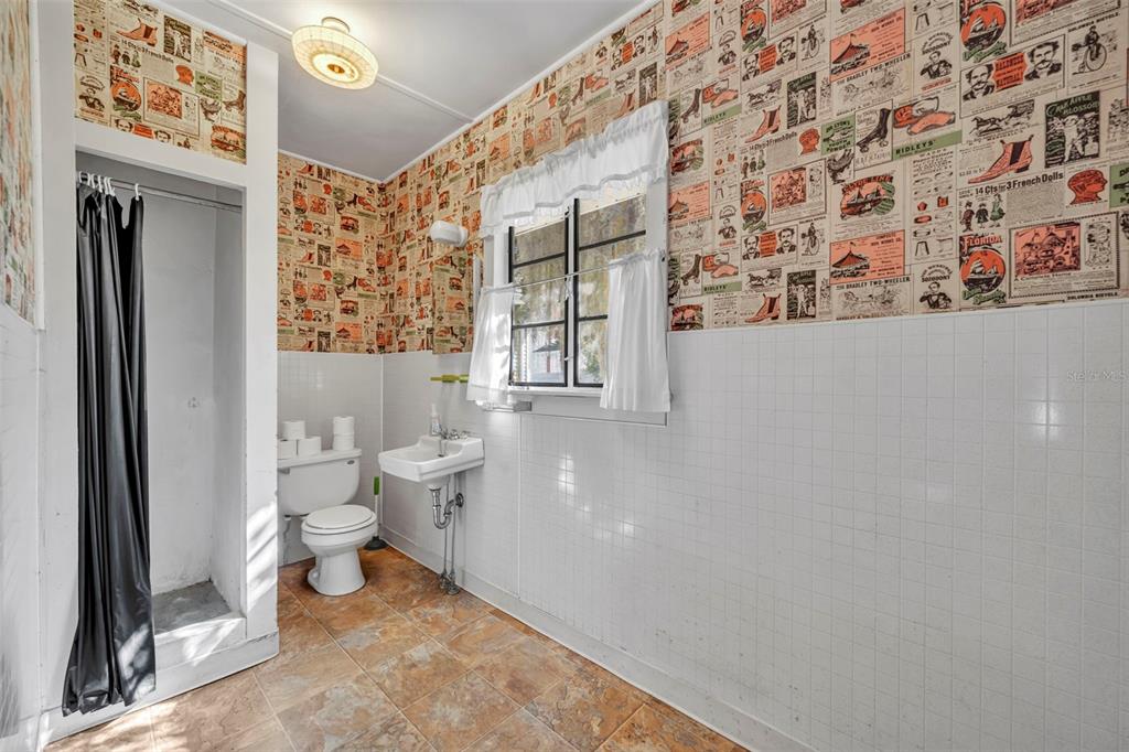 207 Perkins Street Leesburg, FL 34748 - Photo 17 of 31 a bathroom with a toilet and a shower curtain