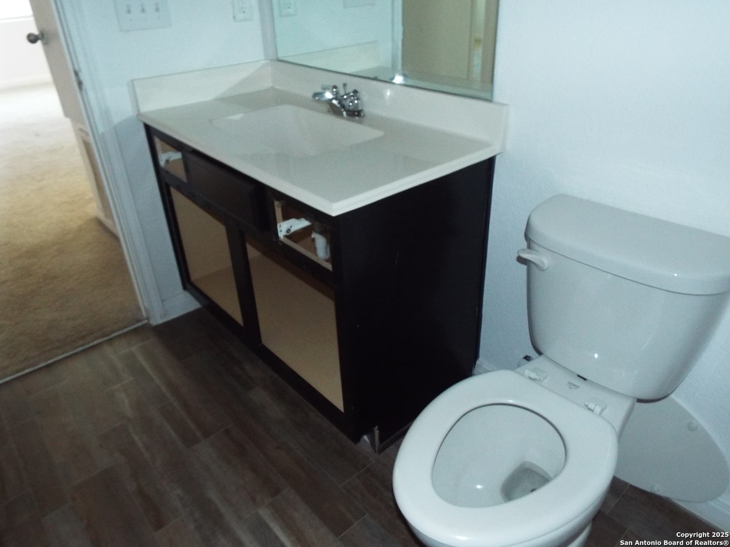 4937 Hallies Garden St. Hedwig, TX 78152 - Photo 20 of 30 a bathroom with a toilet sink and mirror