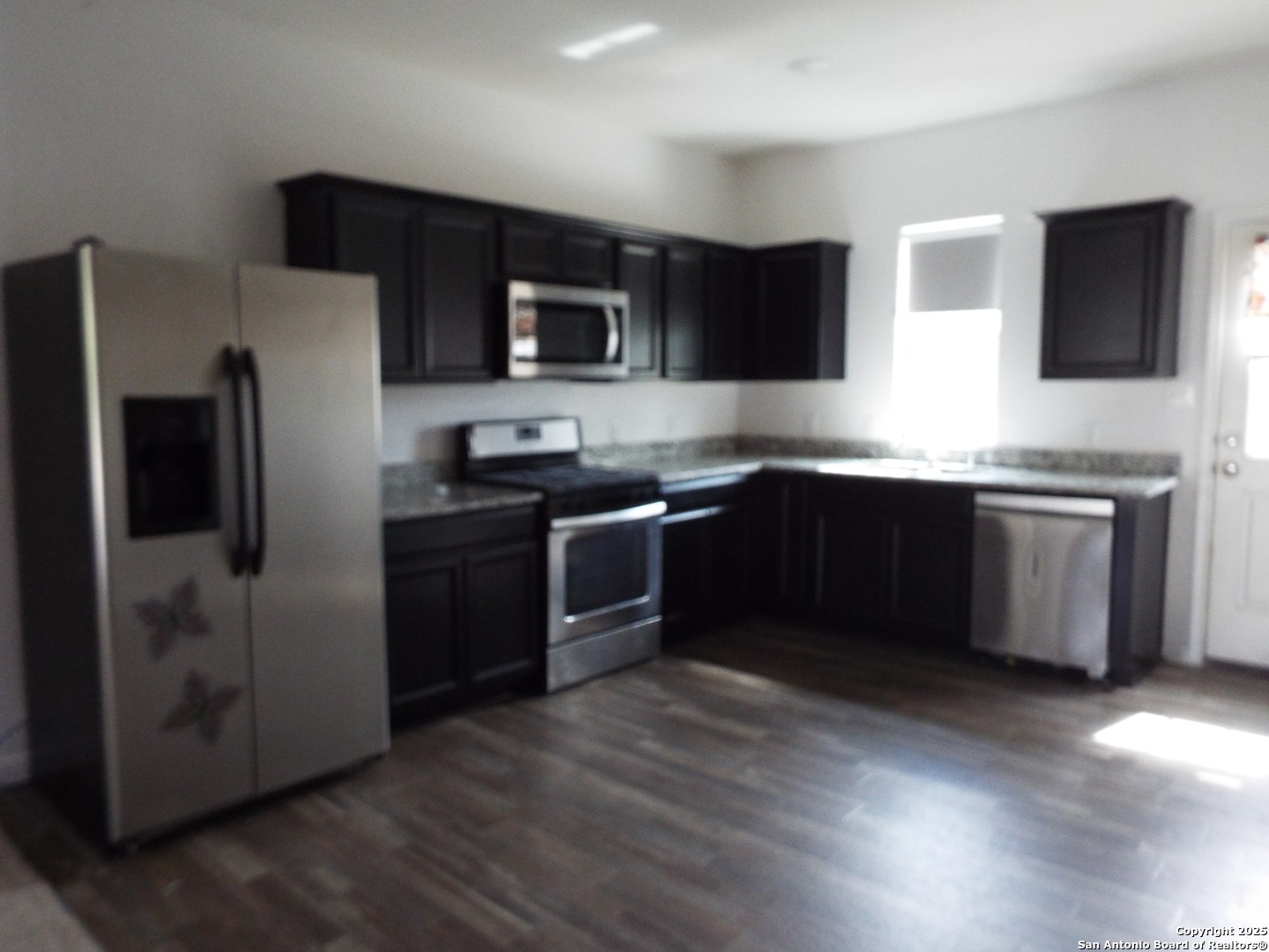 4937 Hallies Garden St. Hedwig, TX 78152 - Photo 3 of 30 a kitchen with stainless steel appliances a sink a stove a microwave a refrigerator a sink and dishwasher