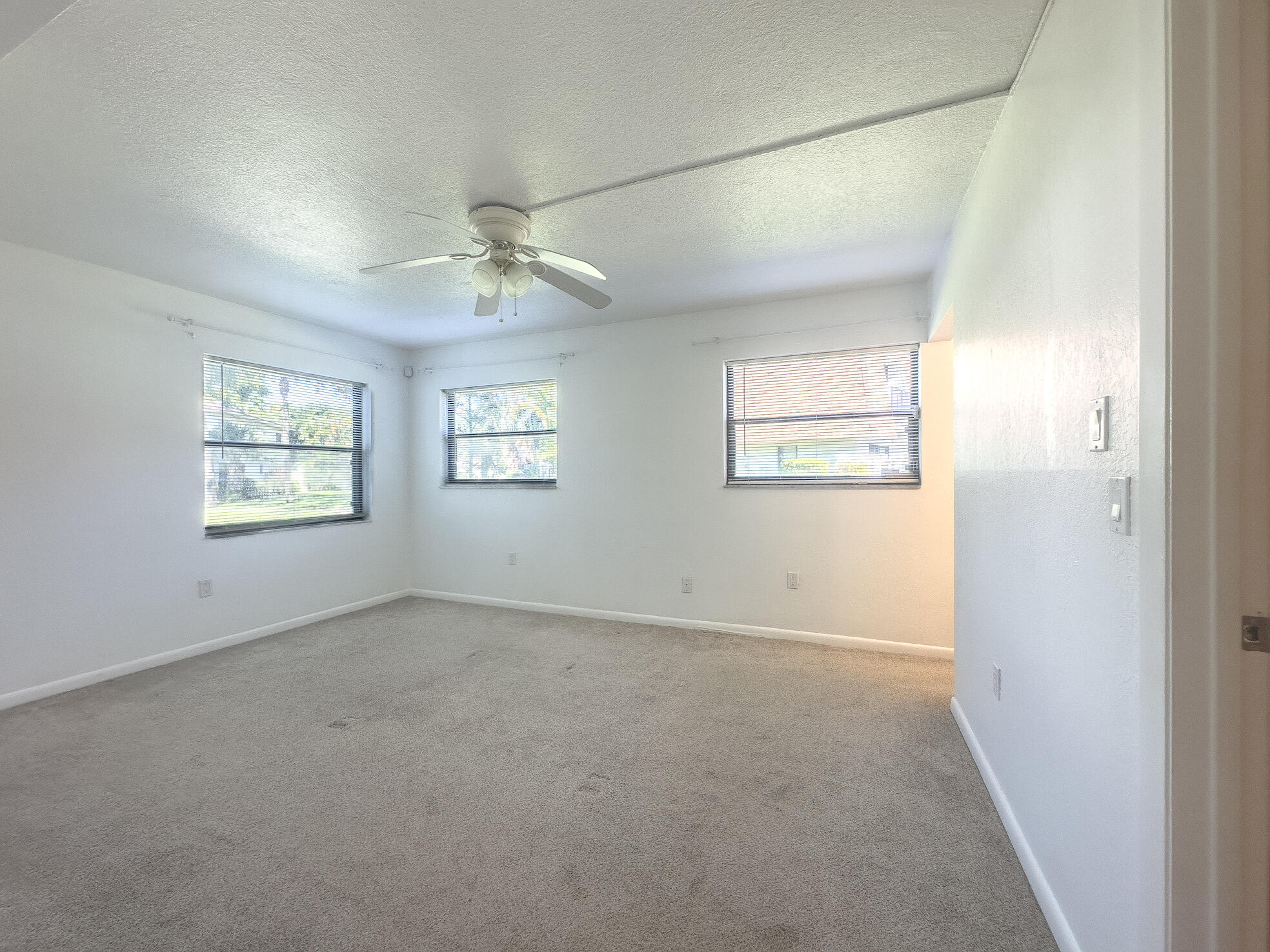 3130 Southwest 20th Terrace, Unit 13B1 Delray Beach, FL 33445 - Photo 19 of 47 an empty room with windows and fan