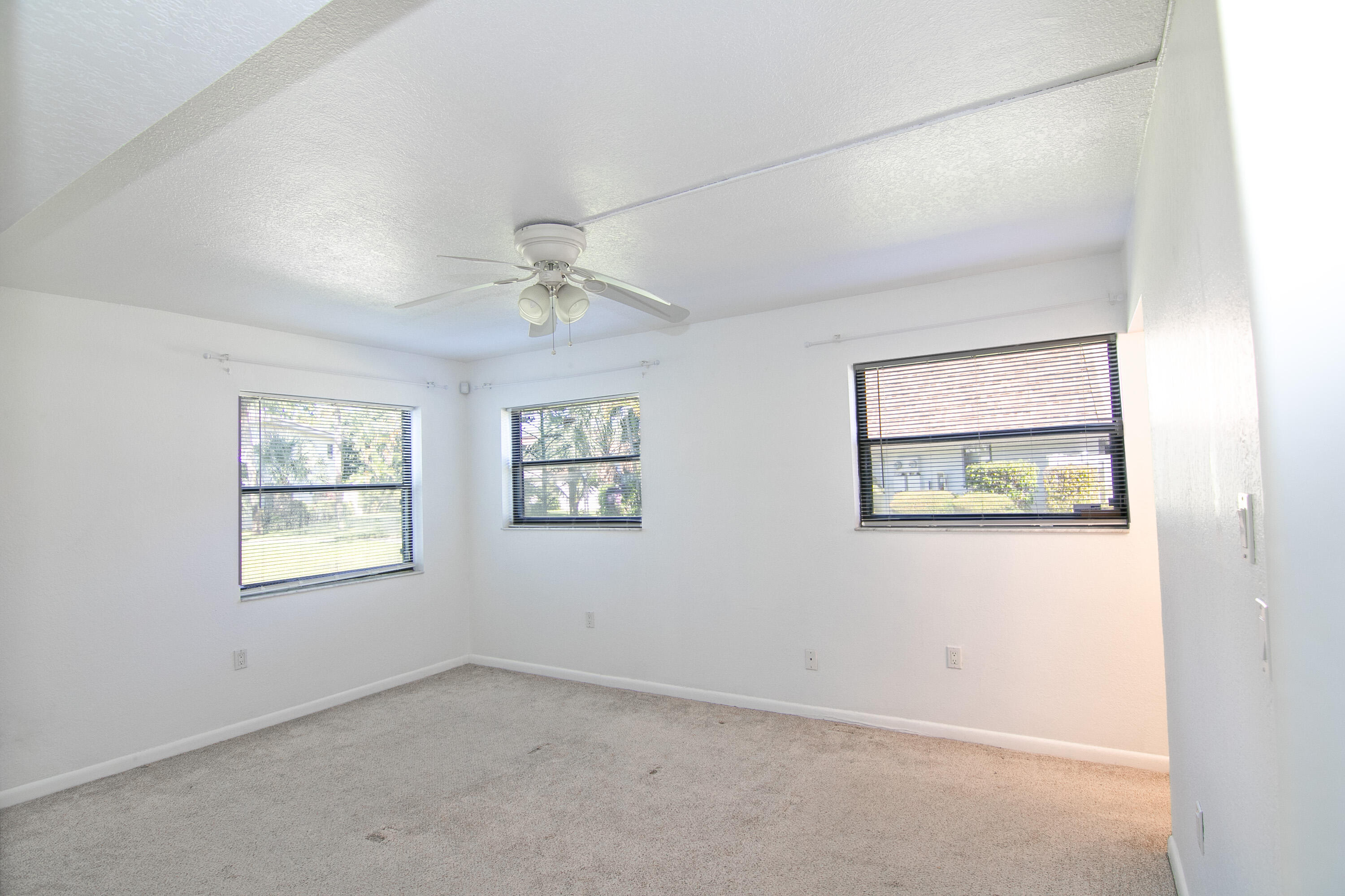 3130 Southwest 20th Terrace, Unit 13B1 Delray Beach, FL 33445 - Photo 20 of 47 an empty room with windows and fan