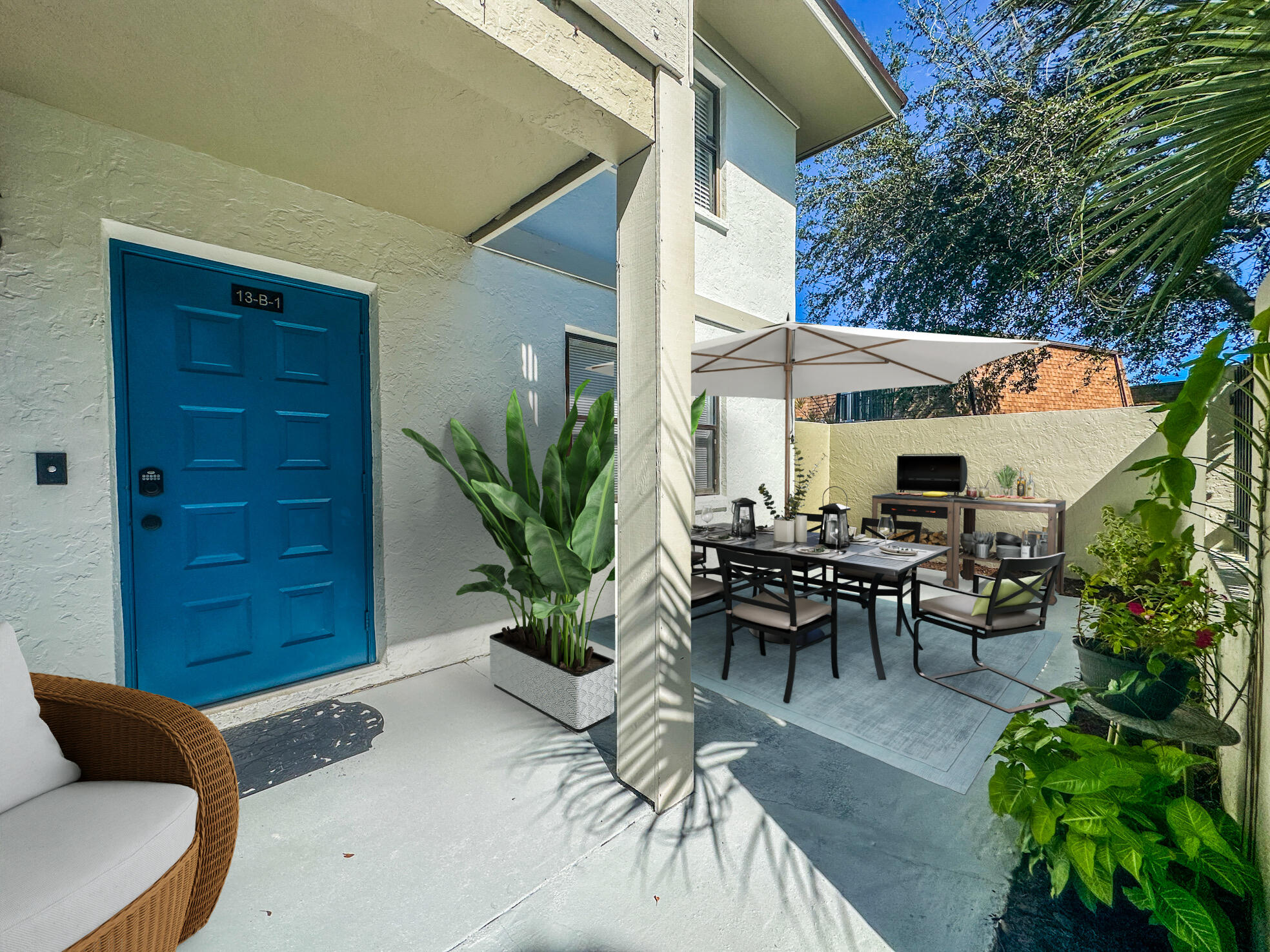 3130 Southwest 20th Terrace, Unit 13B1 Delray Beach, FL 33445 - Photo 45 of 47 a view of a patio with table and chairs potted plants with wooden fence