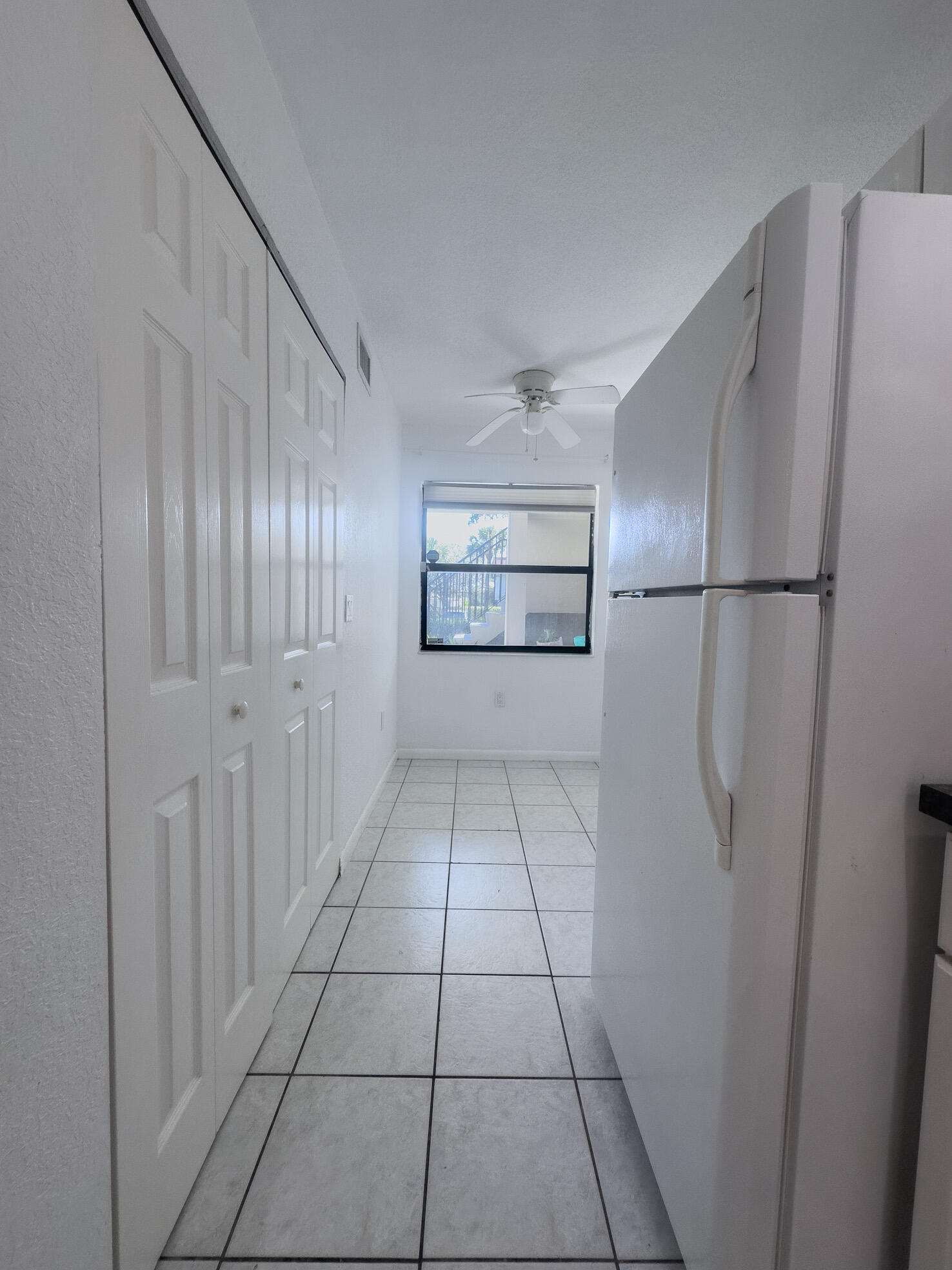 3130 Southwest 20th Terrace, Unit 13B1 Delray Beach, FL 33445 - Photo 8 of 47 a view of a refrigerator in kitchen and entryway