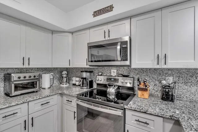 a kitchen with appliances a sink and cabinets