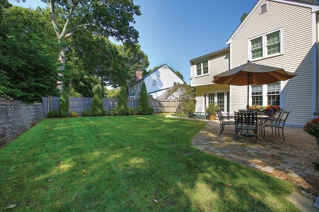 24 Arlington Road Brookline, MA 02467 - Photo 24 of 25 a patio with a table and chairs under an umbrella