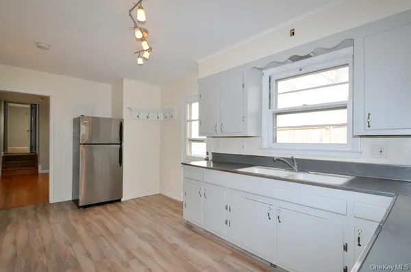 a kitchen with a refrigerator a sink and dishwasher with wooden floor
