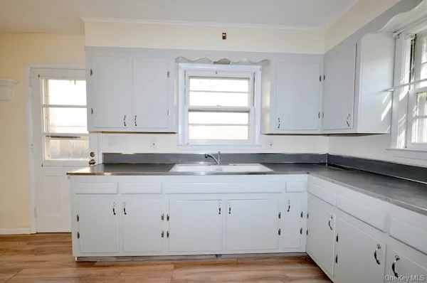 a kitchen with granite countertop white cabinets and a sink