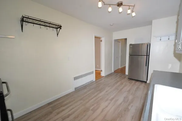 a view of a kitchen with a refrigerator a ceiling fan and wooden floor