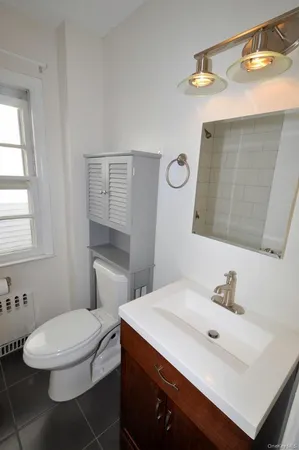a bathroom with a sink mirror vanity and toilet