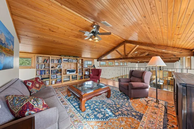a kitchen with stainless steel appliances kitchen island granite countertop a table chairs and a refrigerator