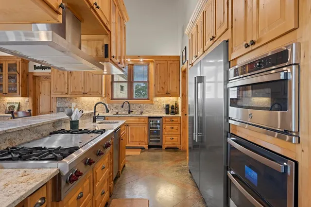 a kitchen with granite countertop a sink stainless steel appliances and cabinets