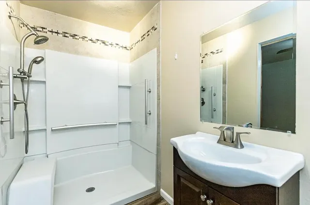 a bathroom with a sink a mirror a shower and a mirror