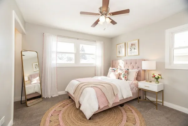 an empty room with windows and fan
